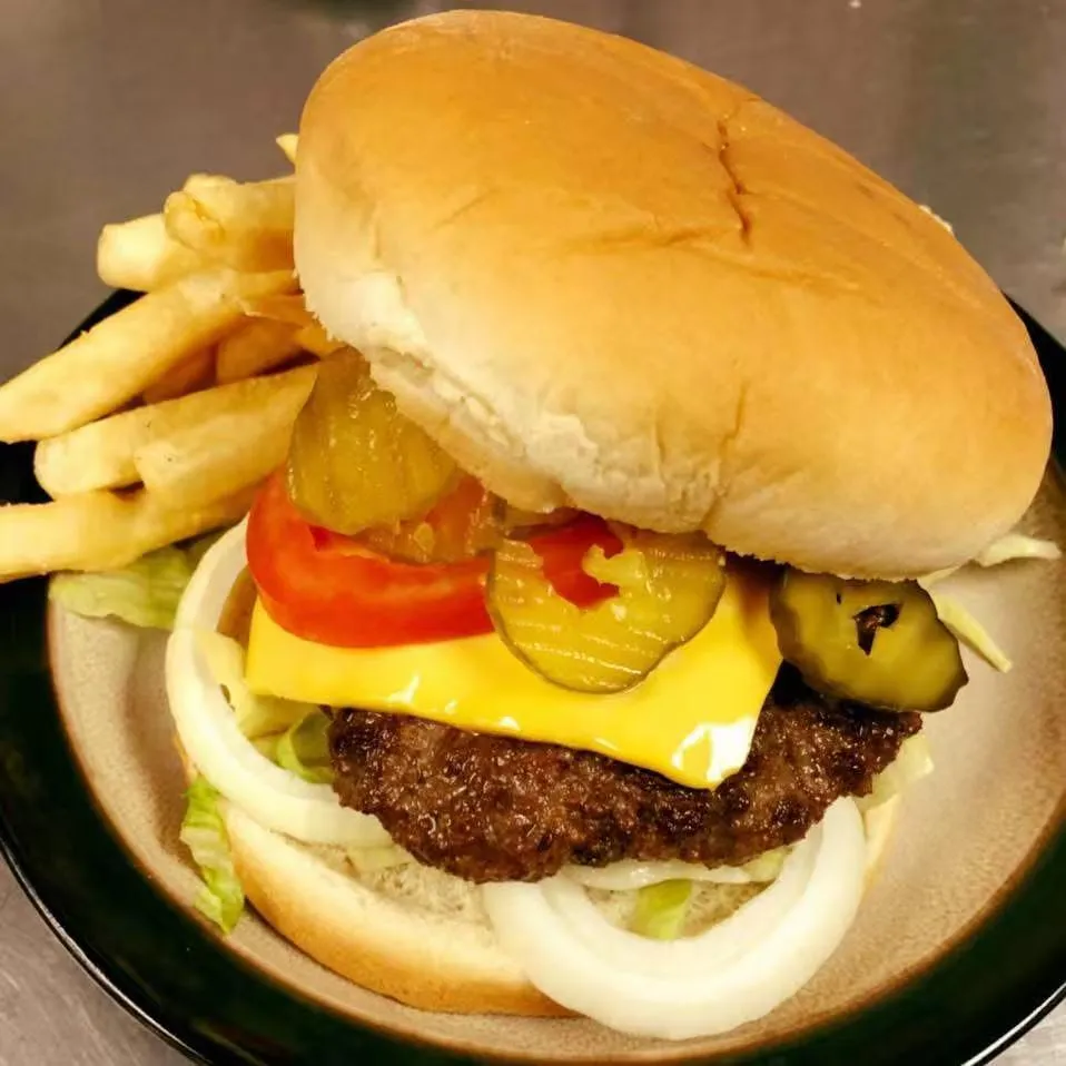 Classic cheeseburger with lettuce, tomato and fries at Tate Cove Seafood, a Fast-Food Restaurant in Ville Platte